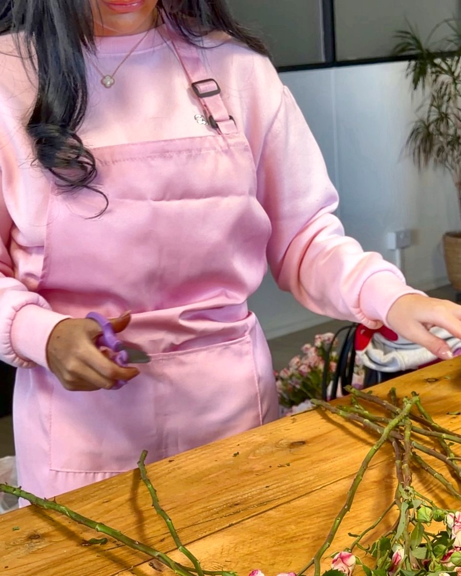 Arranging pink stems on a sunny table