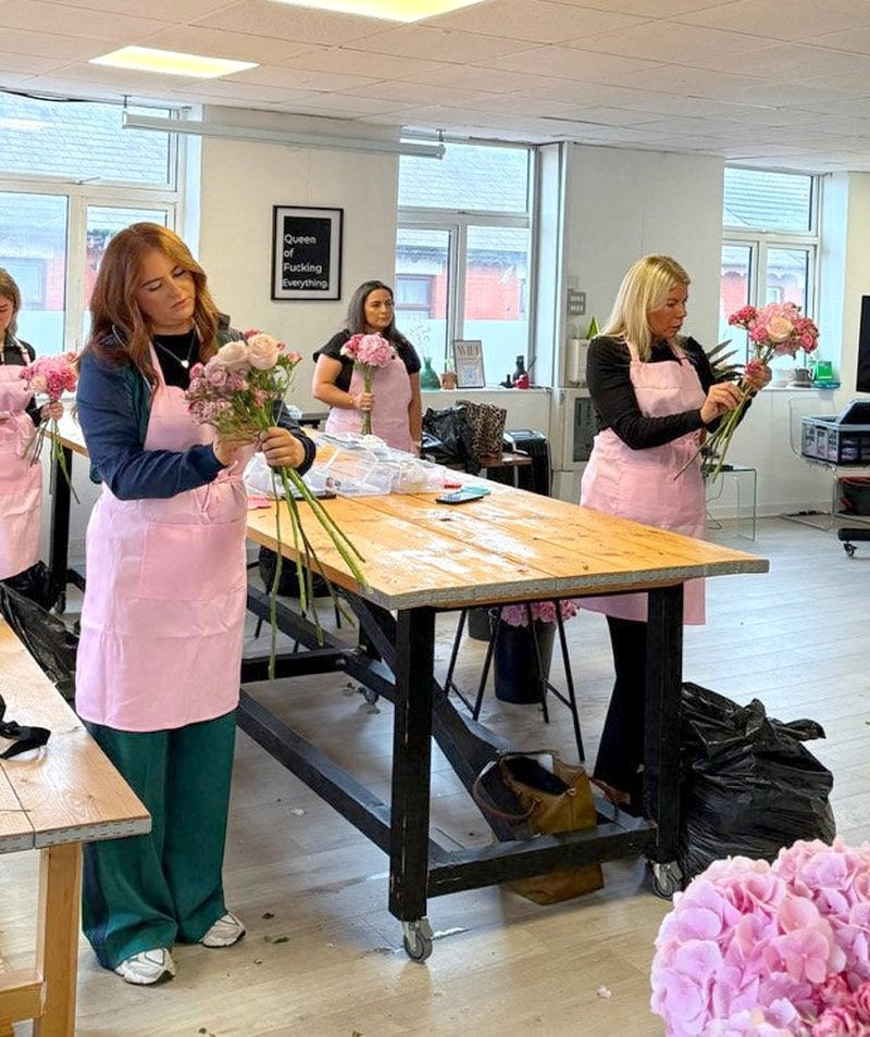 A group of brides-to-be at their workshop tables building with fresh flowers