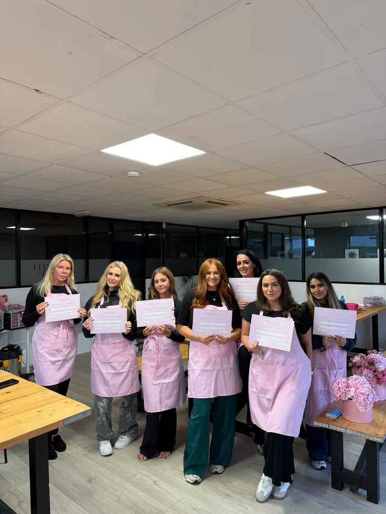 A group of academy students standing together holding their certificates