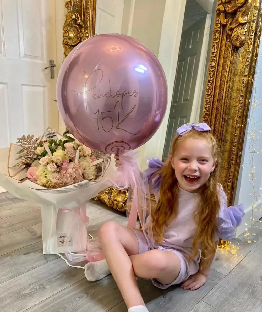 Penelope at home holding a number balloon, celebrating a business milestone