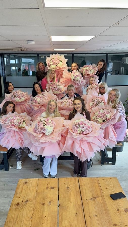 A full training day group with all their bouquets