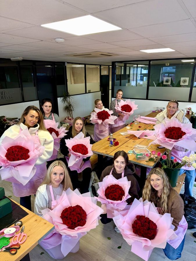 Students smiling with their red rose bouquets