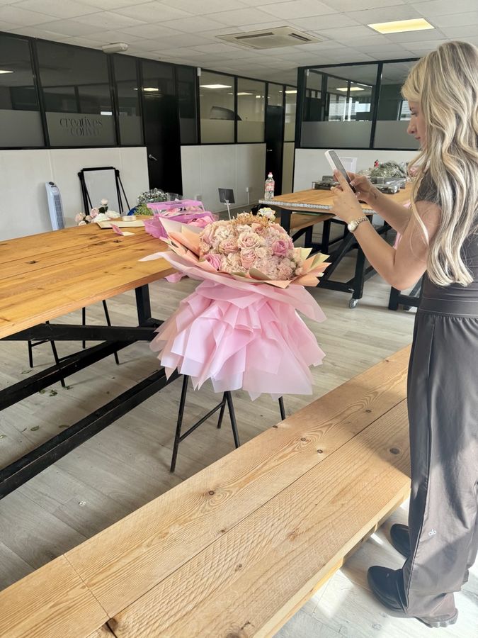 A student taking a photo of her finished bouquet