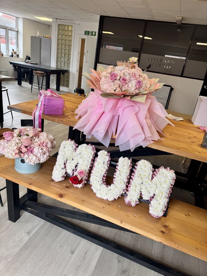 A MUM letter tribute beside a bouquet on the studio table