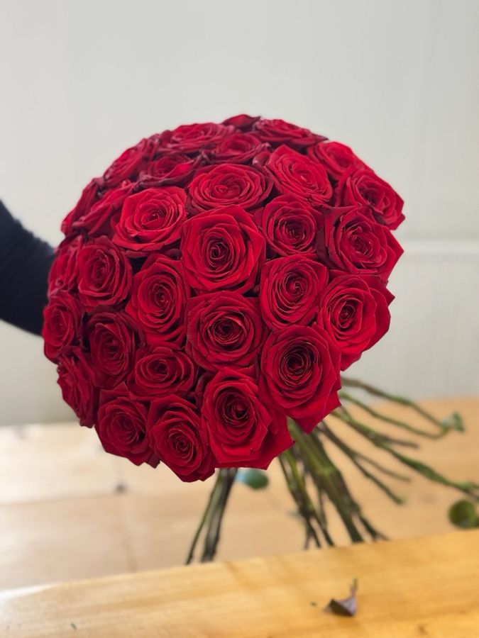 A hand tied bouquet of red roses