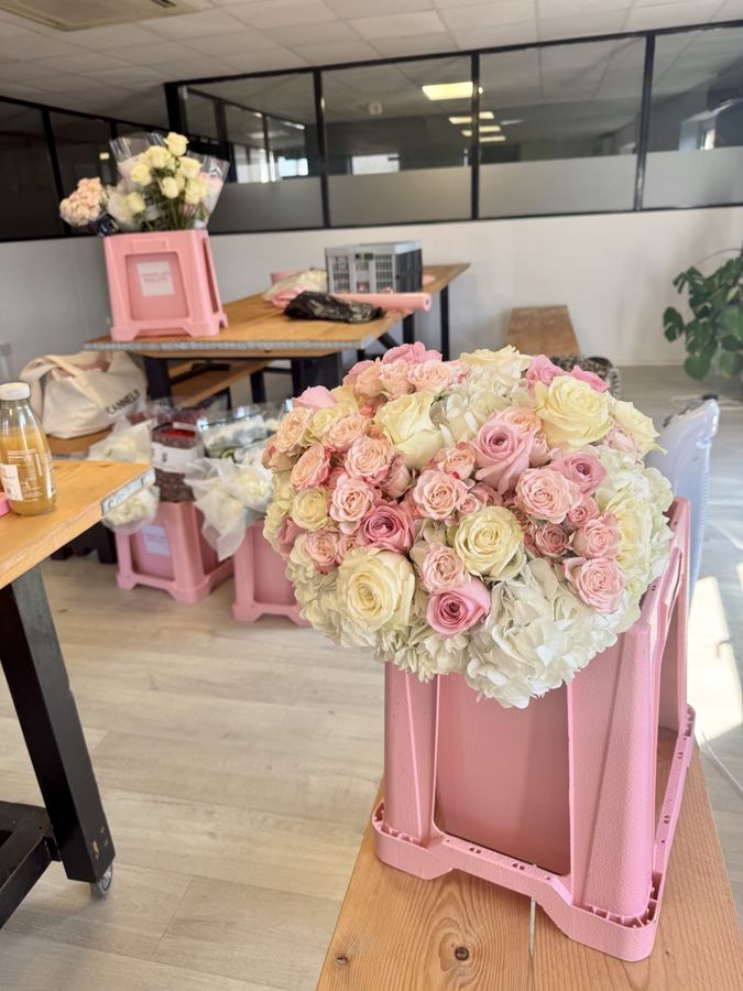 A rose and hydrangea bouquet standing on its pink box